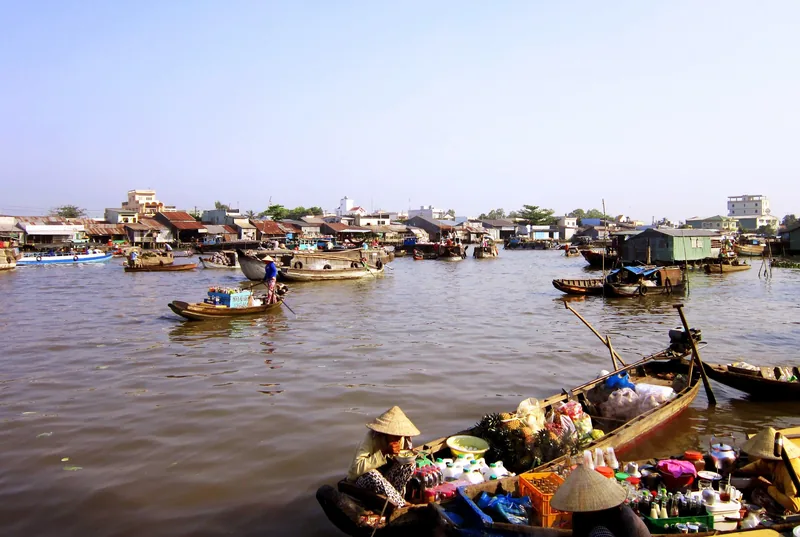 Wooden boats laden with goods gather on the river at Cai Rang floating market in Can Tho.