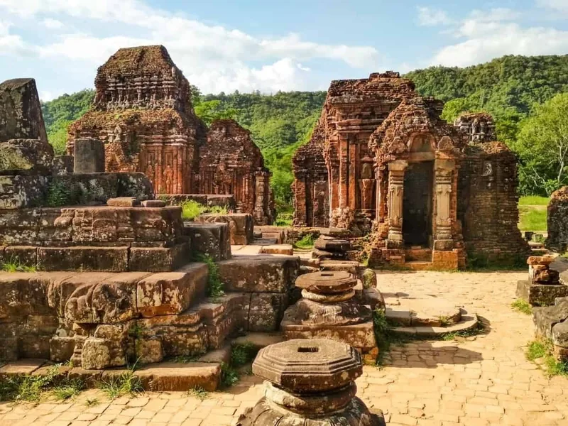Ancient brick towers and stone ruins stand amid greenery at My Son Sanctuary near Da Nang.